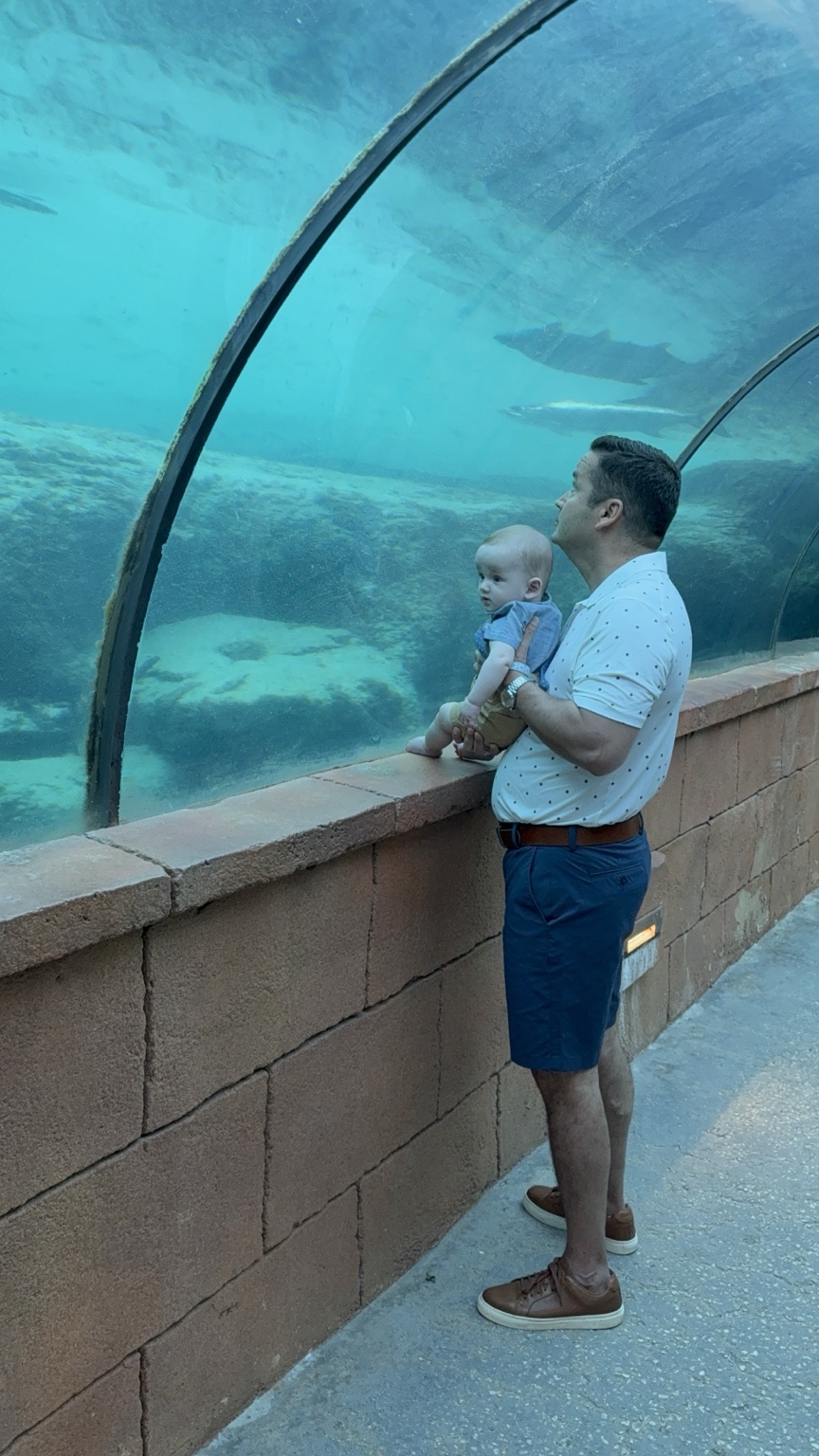 Hassan holding his baby inside an underwater viewing tunnel at Atlantis