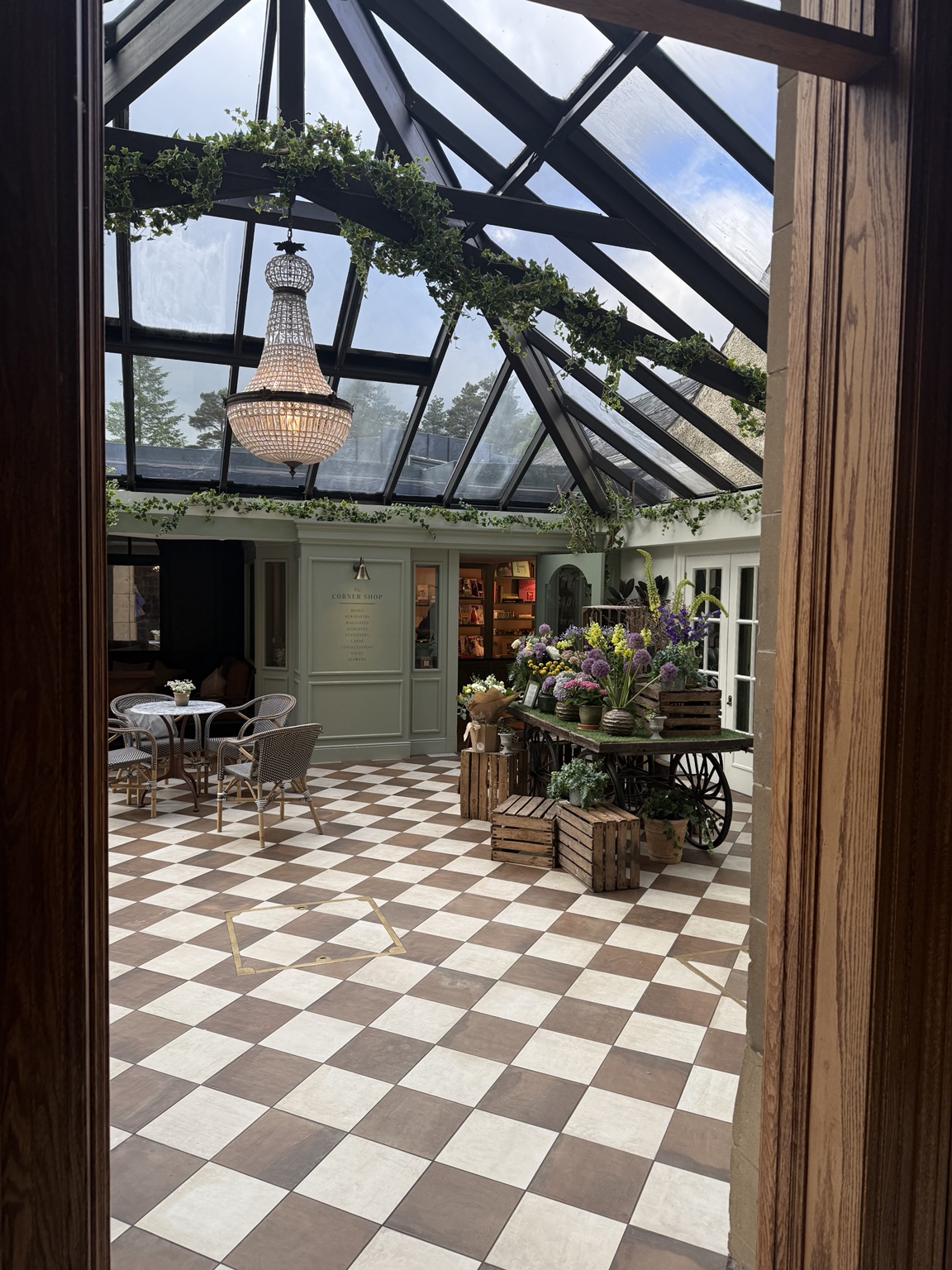 The glass-roofed central atrium at Gleneagles with flowers and café seating