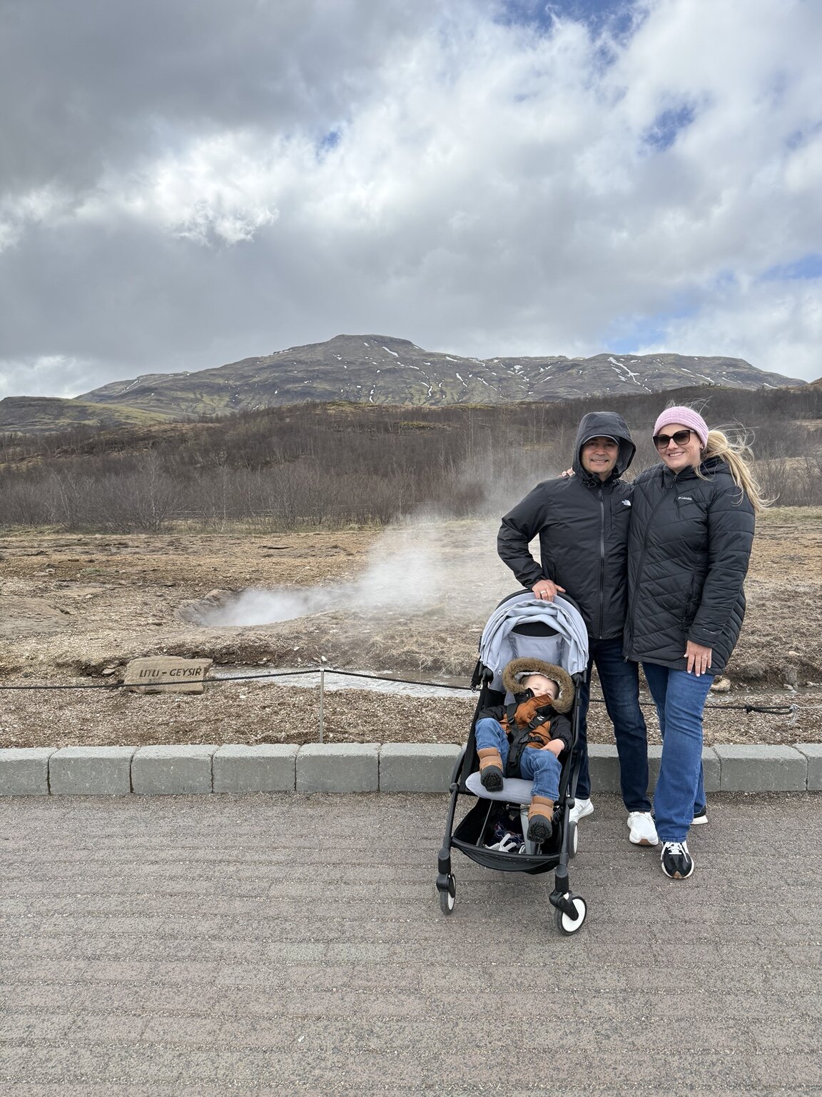 Jeni, Hassan and their toddler together at the Geysir geothermal area in Iceland