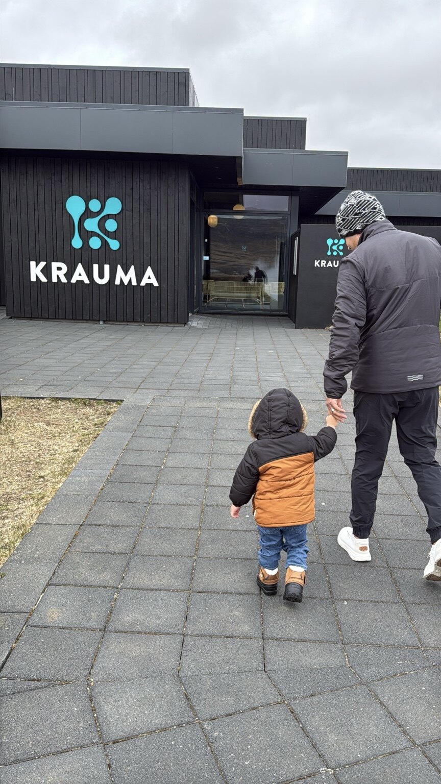 Hassan and his toddler walking hand in hand toward the entrance of Krauma