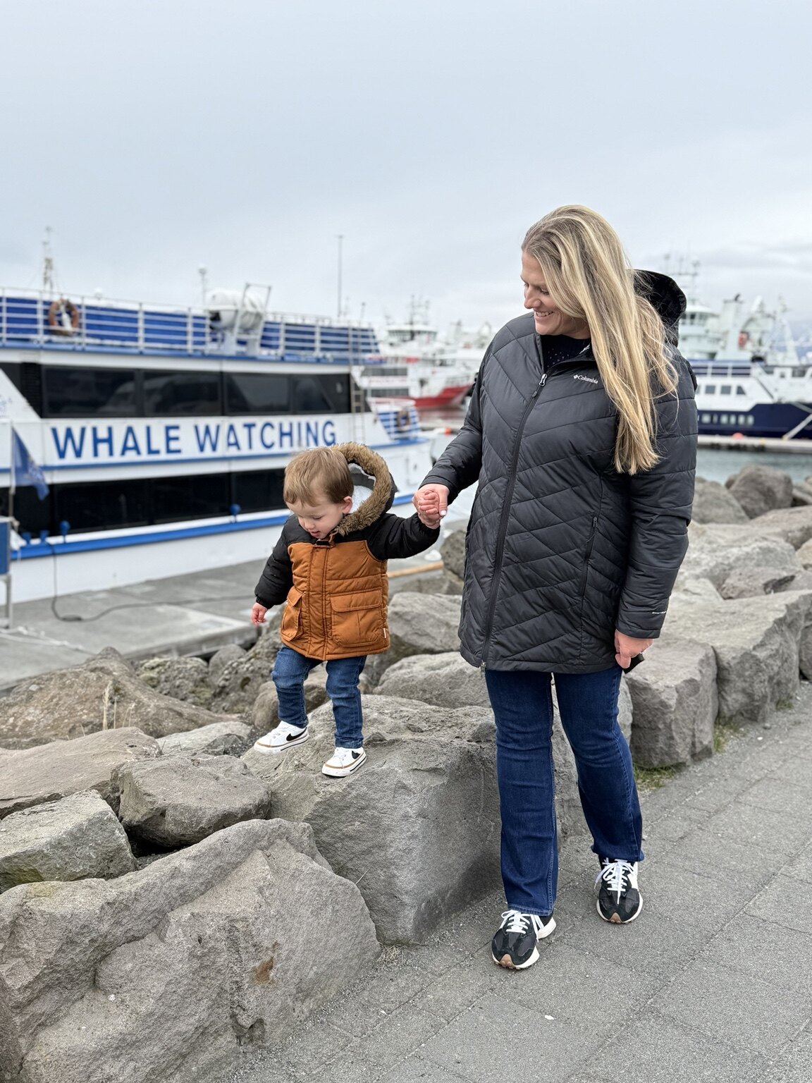 Jeni and her toddler exploring the rocks beside Reykjavík's Old Harbour