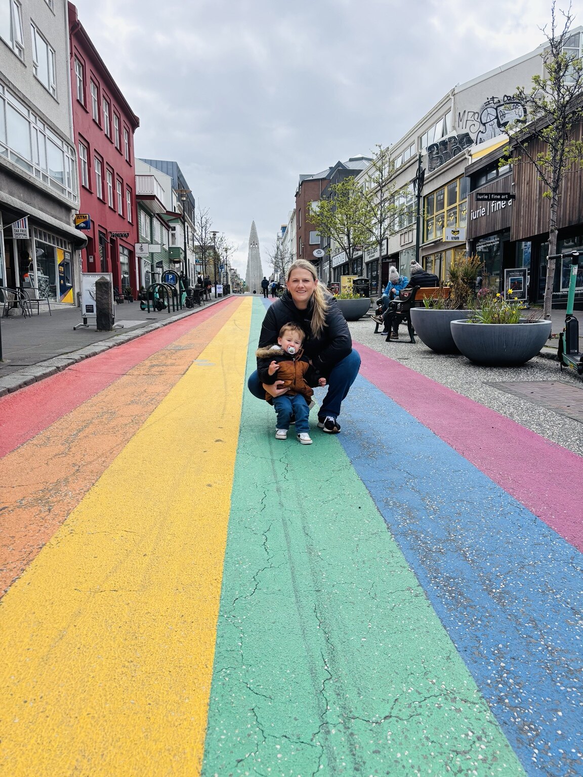 Jeni and her toddler together on Reykjavík's colorful Rainbow Street