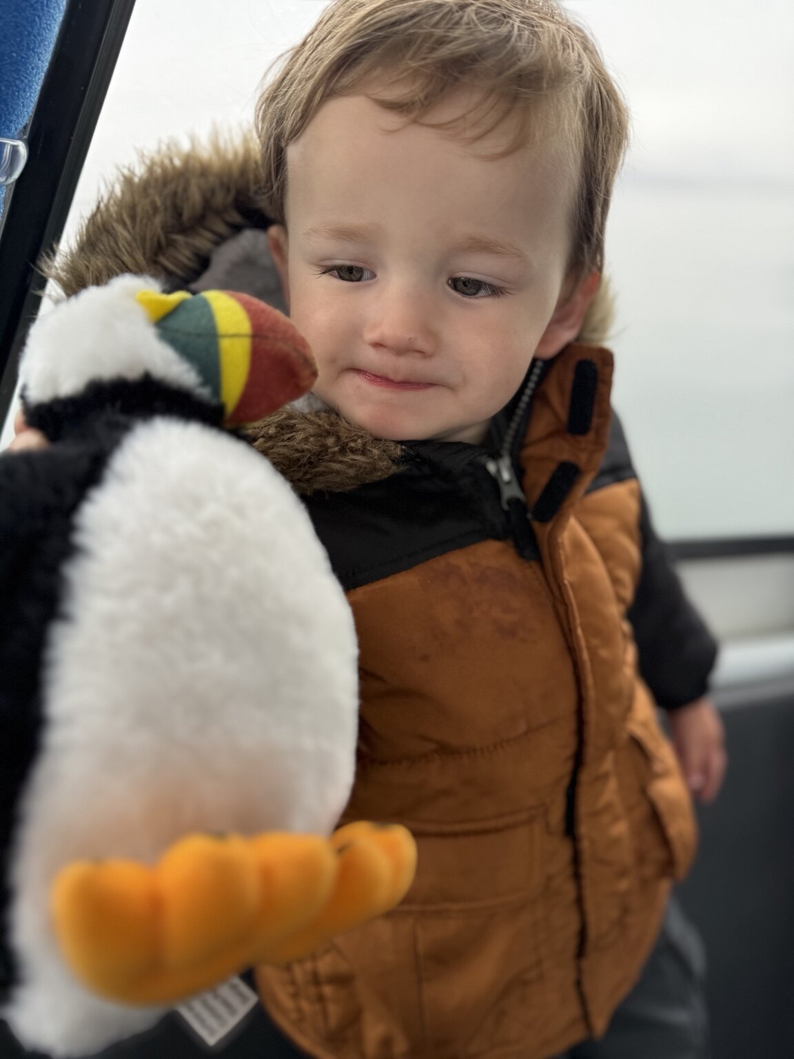 Jeni's toddler holding a stuffed puffin during the Reykjavík boat tour