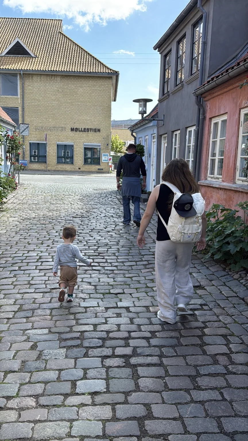 Family strolling along a cobbled street in Aarhus