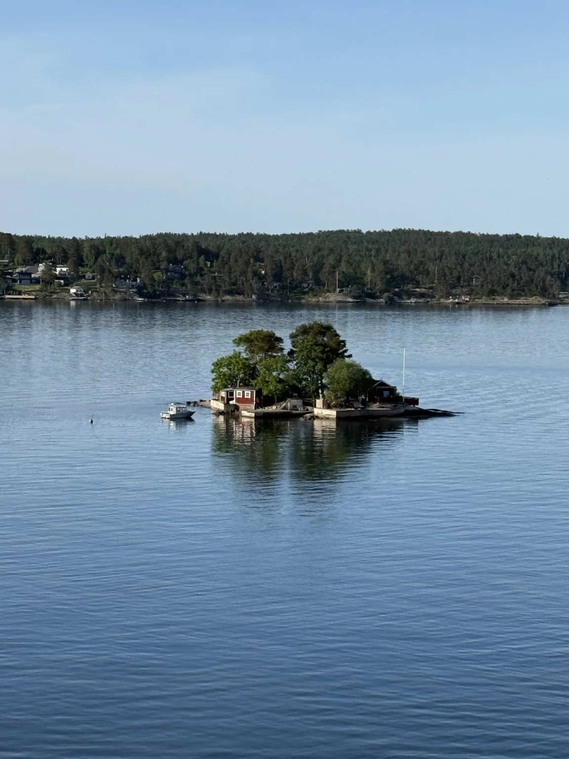 A tiny island with red cabins on the approach to Stockholm