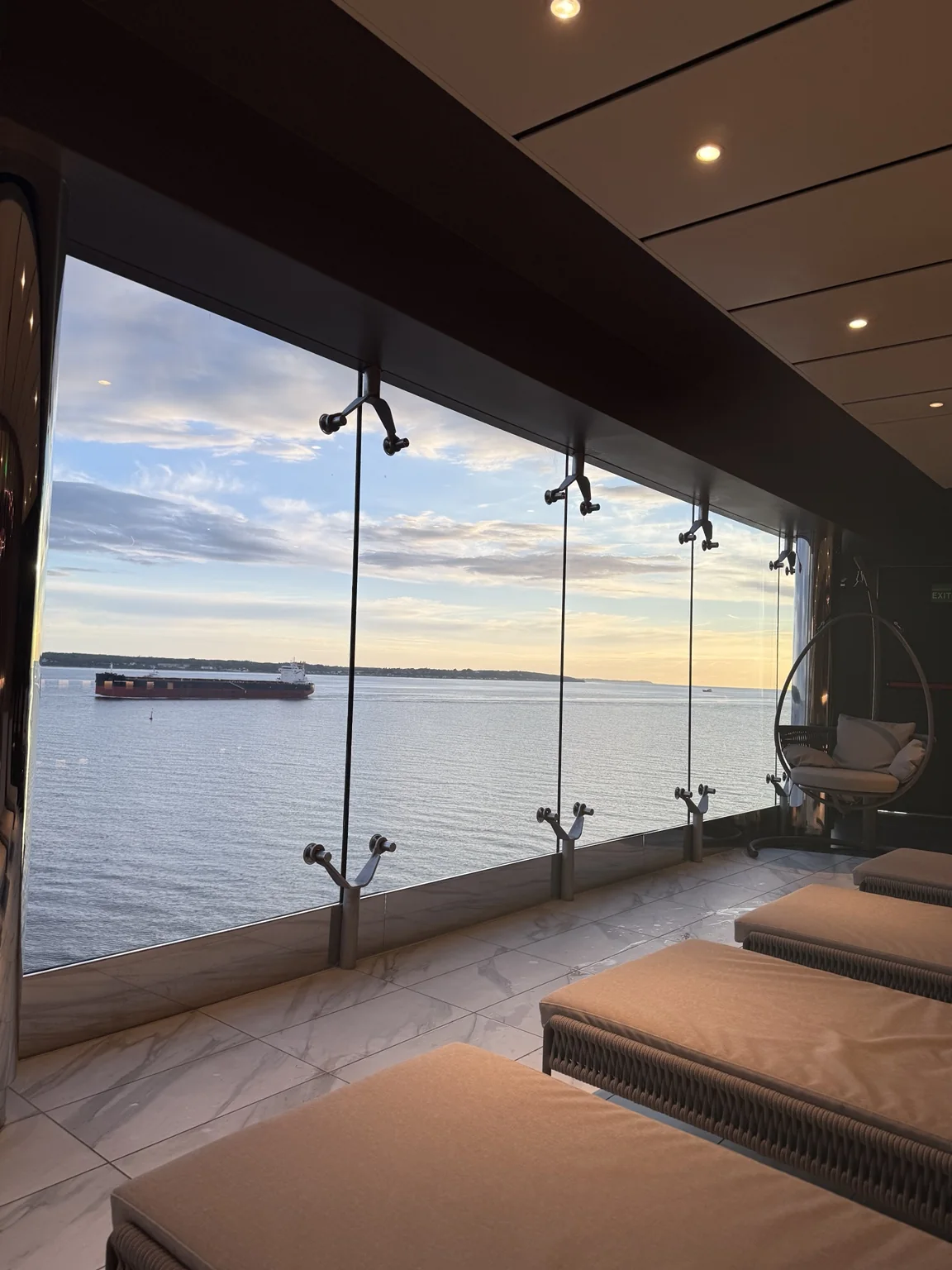 Spa loungers beside panoramic windows overlooking the sea