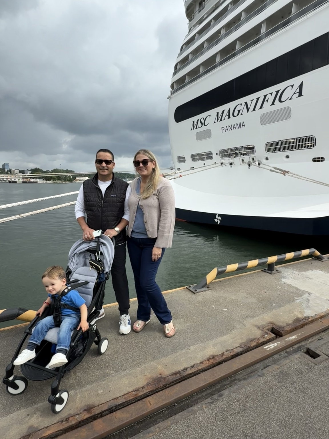 Our family beside the MSC Magnifica, with our toddler seated in a stroller