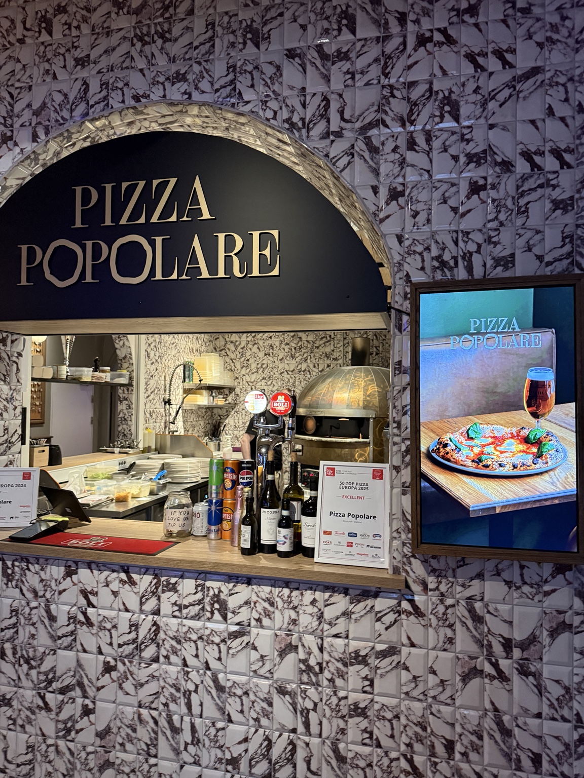 Pizza Popolare’s tiled counter and pizza oven inside Pósthús