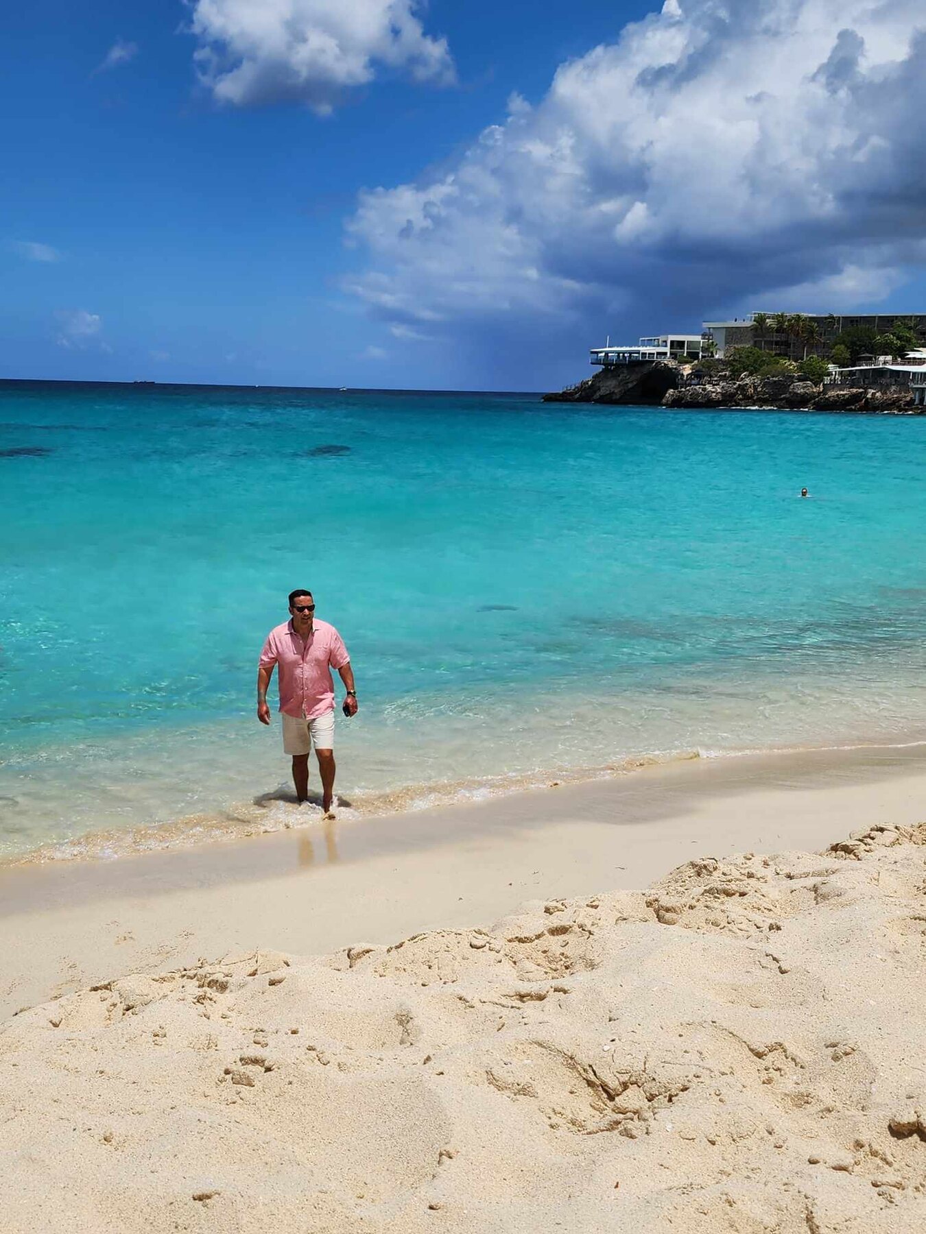 Hassan standing in bright turquoise water on Saint Martin