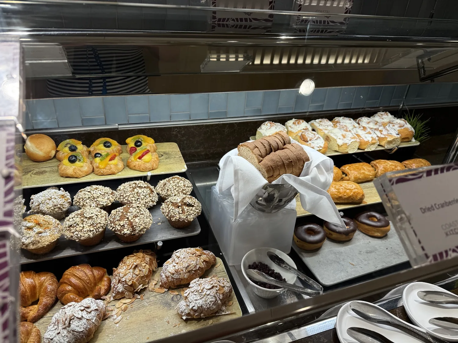 Pastries and muffins arranged on the snack counter in the Coastal Kitchen lounge area
