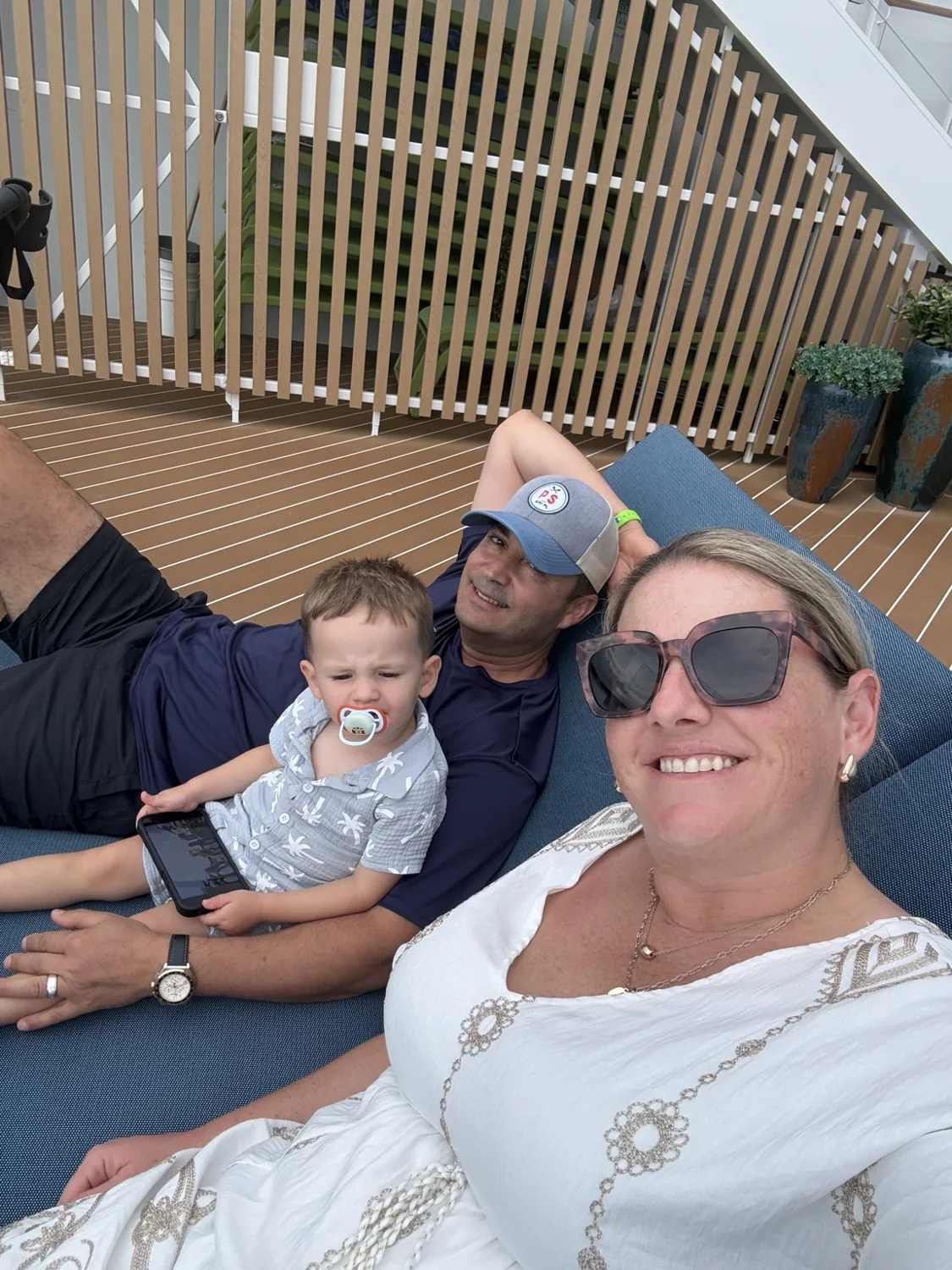 Our family relaxing together on a cushioned lounger on the suite sun deck